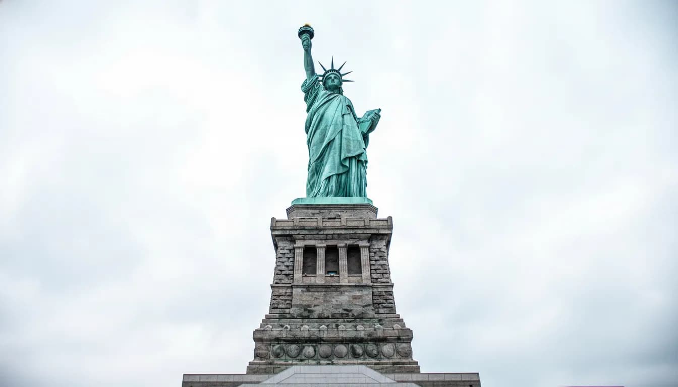 Full view of Statue of Liberty on pedestal with overcast sky